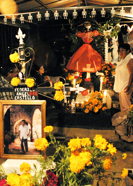 Decorated grave with family for the Day of the Dead