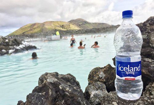 Bottle of drinking water in front of hot springs in Iceland. 