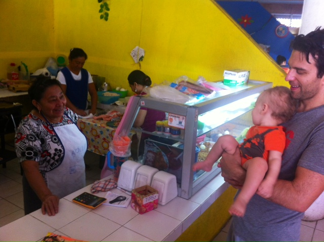 Vendor and baby inside a market on Isla Mujeres