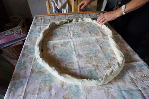 Rolling up stuffed burek, or pita, dough before cooking it, in Bosnia.