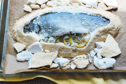 Sea bass baked in a salt crust, shown during preparation