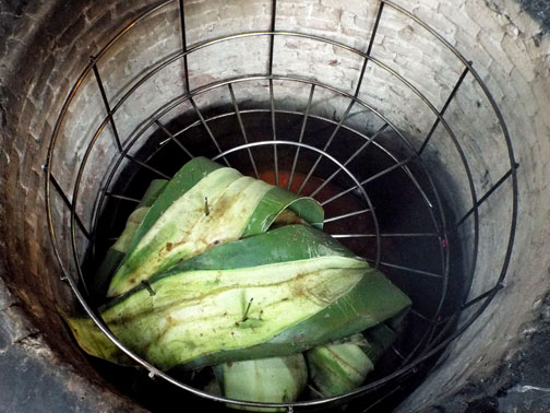 Leaf-wrapped meat going into an oven to make barbacoa, Mexico City.