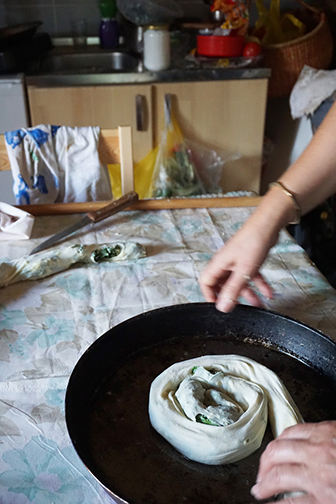 Spriling the burek, or pita, dough into a pan, at a cooking class in Bosnia.