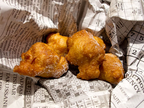 Freshly fried beignets in a newspaper from Dakar, Senegal.