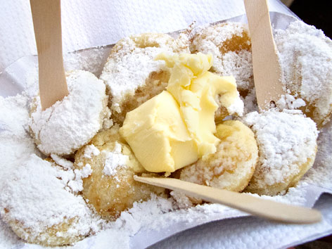 A container of poffertjes with butter and powdered sugar from the Noordermarkt in Amsterdam, the Netherlands