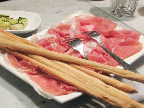 A plate of prosciutto di Parma with breadsticks in Modena, Emilia-Romagna, Italy