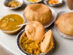 Bowls of bedmi aloo and nagori halwa from Shyam Sweets in Delhi, India. 